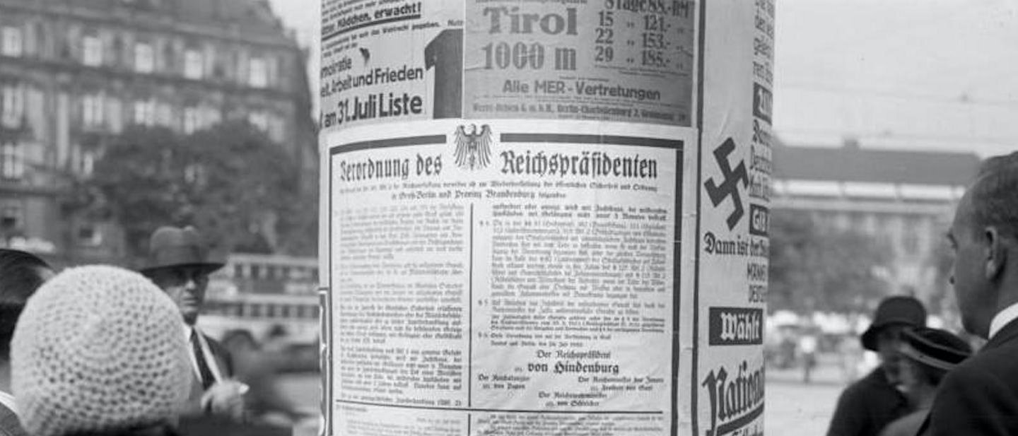 A German street column in 1932 displaying a presidential emergency decree by Paul von Hindenburg alongside Nazi election posters.